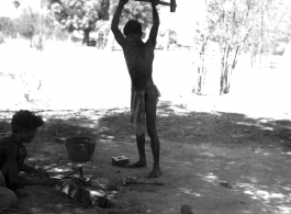 Men working metal in shade of tree.  Scenes in India witnessed by American GIs during WWII. For many Americans of that era, with their limited experience traveling, the everyday sights and sounds overseas were new, intriguing, and photo worthy.