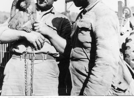 At the Tengchong cutoff: Convoy driver Sgt. Eric J. Neilson, driver of the SOS convoy that went over the Tengchung cut off of the Stilwell Road is shown looking at the pet monkey of a Chinese soldier.  Yunnan Province on March 4, 1945.  Photo by T/Sgt. Greenberg.  Passed by William E. Whitten.