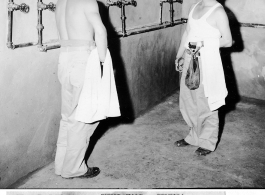 Two patients at the Convalescent Camp (#3) in Kunming, China, look with anticipation at the shower rooms being erected for their comfort. Two shower rooms are nearing completion, each having 6 showers and a large adjoining washroom. The buildings are of brick and will have both hot and cold water.  June 19, 1945.  Photo by T/4 Louis Raczkowski. 