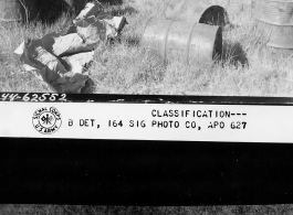 View of burned gasoline drums, shell fuses, etc., gathered by Japanese for salvage from destroyed Chinese dump north of Zhefang.  December 5, 1944.  Photo by T/5 William E. Shemorry. 164th Signal Photographic Company, APO 627.  Passed by William E. Whitten.