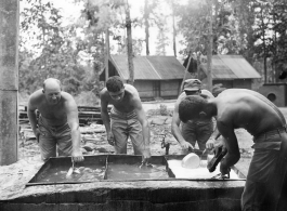 GIs of 797th Engineer Forestry Company washing their eating utensils in Burma.  During WWII.