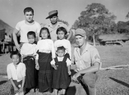 Local people in Burma near the 797th Engineer Forestry Company--GIs pose with local Kachin man and several children in a village.  During WWII.