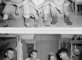 Engineers of the 797th Engineer Forestry Company pose in their tent in Burma, and while playing cards. The man on the far left (with a smile) is holding all aces.  During WWII.