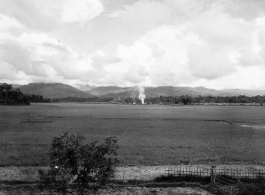 Smoke rising from distance village in Burma.  During WWII.  797th Engineer Forestry Company.