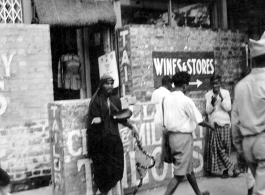 A fakir on the street in India, as an American Black GI walks by, as seen by men of the 2005th Ordnance Maintenance Company, 28th Air Depot Group, in India during WWII.