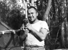 Irwin W. Hayden of the 2005th Ordnance Maintenance Company,  28th Air Depot Group, holds gang mascot, the dog "Evan."