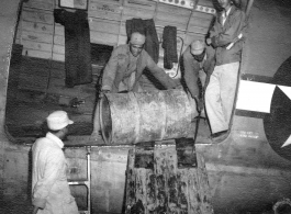 Chinese workers unloading barrels from a C-46 transport during WWII.