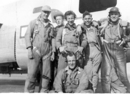 Members of Poston crew pose jovially with B-24 bomber of the 9th Bombardment Squadron, 7th Bombardment Group, 10th Air Force, on concrete of air base during WWII.