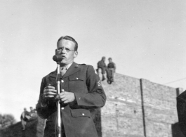 Enlisted man sings at a USO show in Gushkara, India, during WWII.