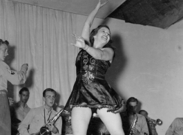 Tap dancer at a USO show in Gushkara, India, during WWII.  The boxes in front of the band players are labeled 748th ROB (748th Railway Operating Battalion).