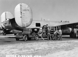 Loading film into 24th Mapping Squadron F-7A, #441678, from photographic equipment carrying trailer. February 22, 1945.