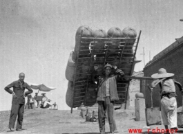 Man shoulders sheep-skin raft in northern China during WWII.