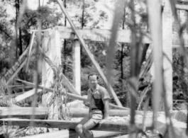 Friend of Bob Riese poses amongst remains of aircraft factory and hangers at the air base at Liuzhou, in 1945. The facilities at the base were first destroyed by the Chinese and Americans during retreat in the face of Ichigo during the fall of 1944, then may have been destroyed more by American bombardment during Japanese occupation, and possibly destroyed more by the Japanese as they retreated the area in 1945.