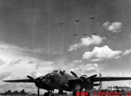 A B-25 on the ground at an American air base in Guangxi province, China, during WWII, with six B-25s flying in formation overhead.
