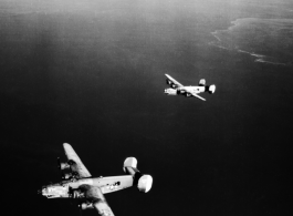 B-24 bombers in flight over water in the CBI, with "Spare Parts" on the left.  Note the shark teeth on the nose of each.