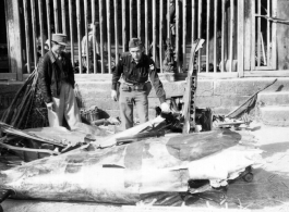 American and Chinese soldiers look over remains of a crashed Japanese airplane in the CBI during WWII.