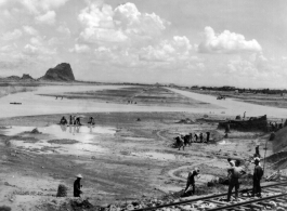 An airstrip under construction near a railroad, in a region of karst formations.  This is almost certainly Liuzhou, in Guangxi province.