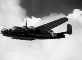 491st Bomb Squadron aircraft #438, a B-25J appears smooth in formation flight in spite of large, turbulent clouds filling the China sky behind it. Notice the barrels of three .50 caliber machine guns sticking out of the nose of the aircraft. One is a flexible gun, used by the bombardier or navigator to defend the nose from attack.  The other two are hard mounted to the lower, right side of the bombardier's area. The pilot fires them simultaneously with four mounted to the sides of the aircraft for straffing