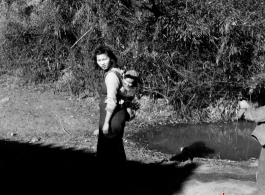 A woman carries a baby on her back in Yunnan province, China, during WWII.