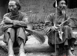 Men smoking pipes in a village in Yunnan, China, during WWII.