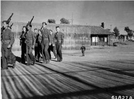 Outfitted with a garrison cap, a tiny pistol and cut-down GI pants, Saio Lau Hu (otherwise known as "Little Tiger Joe") works his little legs like pistons trying to keep up with his foster fathers, during WWII in China, fall 1944.