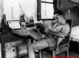 David Firman reads a magazine in his quarters in China during WWII.   From the collection of David Firman, 61st Air Service Group.