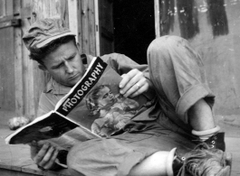 GI reading a Photography magazine at an American installation in the CBI, during WWII.