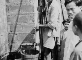 Local people drawing water from a well in China during WWII.  Photo from M. J. Hollman.