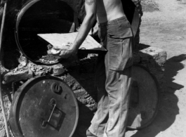 *******A young GI chef, cigarette in mouth, attends to his simple oven full of baked goods. In the CBI during WWII.  Photo from Glenn Hensley.