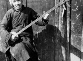 A man plays a three-string Chinese lute ( 三弦) in the CBI during WWII. 