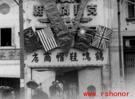 Victory "V" over shoe store in China at the end of the war, with the four flags of the Allies.