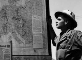 A GI reads about the war on a news board in Akyab.