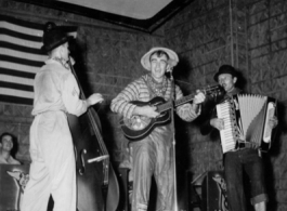 Costumed men perform music, while the "Jive-o-Lieps" of the 54th Air Service Group wait their turn In the CBI during WWII.