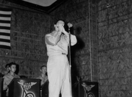 A GI plays harmonica as part of performance, while the band Jive-o-Lieps waits their turn. 54th Air Service Group.