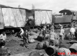 Chinese workers sorting through the aftermath of Japanese bombing raid on railway with load of fuel barrels. Liuzhou, China, September 1944.  From the collection of Frank Bates.