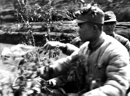 Chinese soldiers riding a motorized vehicle during exercises in southern China, probably Yunnan province, or possibly in Burma, riding a motorcycle.