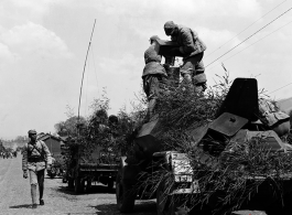 Chinese soldiers making final preparation on armored vehicles, and covered in camouflage during exercises in southern China, in Yunnan province.