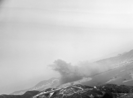 Smoke arises in the distance after an American attack on Hong Kong harbor during WWII.