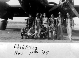 Men pose before C-46 at Zhijiang (Chihkiang) in China during WWII, on November 11th, 1945.  Back: Fong, Capt. Maher, Ehle, Gilfix, Rickards  Front, kneeling: Chung, Capt. Ghent, Scocca, Col. Kernan