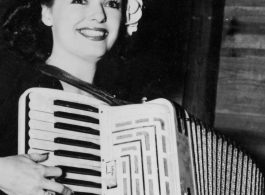 Celebrities visit and perform at Yangkai, Yunnan province, during WWII: Ruth Dennis poses with the accordion.