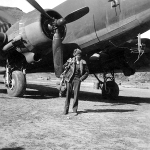 Photographer Edward Harold Dixon standing before a C-47 at a base in China, during WWII.