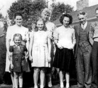 Clarence I. Anderson, Pvc., Service No. 19059691, in the back row in uniform in 1943, in Seattle, WA, with his younger brother and three younger sisters, as well as his mother Ester (far left) and father Ivan (second from the right). 