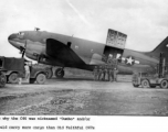 A C-46 Dumbo cargo airplane, #112413, on the ground, with cargo handlers, in the CBI.