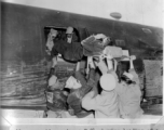 Air evacuation using a B-24 showing loading of a patient through the waist window.
