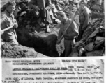 GIs dig slit trench in China during WWII, as local Chinese man looks on. James F. Porter, in center with pick, is digging because of a penalty for infraction of regulations.