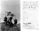 A Chinese laborer carries large buckets of water on a pole up the hill towards the accommodations at Camp Schiel during WWII.