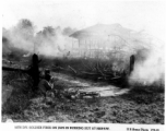 50th Division soldiers fires on Japanese position in burning hut at Hsipaw, Burma, during WWII.