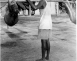 A man shoulders pigs in India.  Local images provided to Ex-CBI Roundup by "P. Noel" showing local people and scenes around Misamari, India.   In the CBI during WWII.