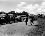 Carts, people, and animals along a road near an American base in Yunnan during WWII.