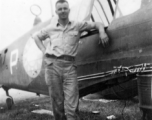 Elmer Bukey posing alongside a salvaged P-40 in the service area at Guilin. During WWII.